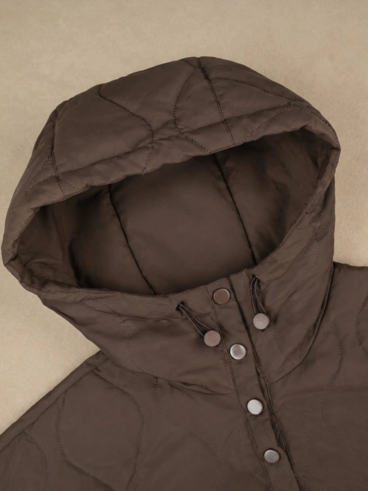 Close view of the adjustable quilted hood and snap placket